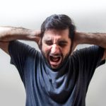 ショックで頭を抱えて叫んでいる男性