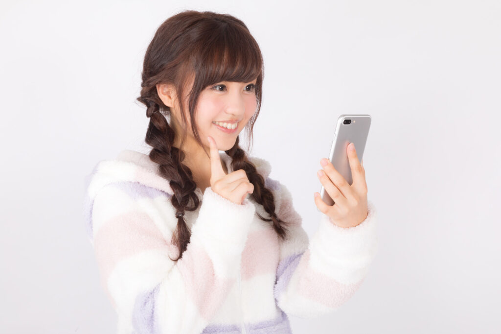スマートフォンを見て喜ぶ女性